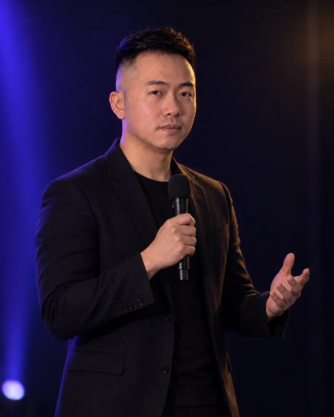 Sean Looi speaking on stage with a microphone